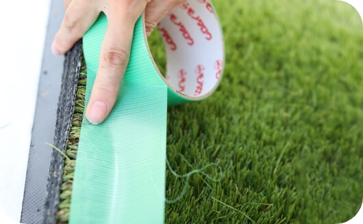 人工芝の端を養生する