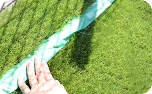 人工芝の端を養生する