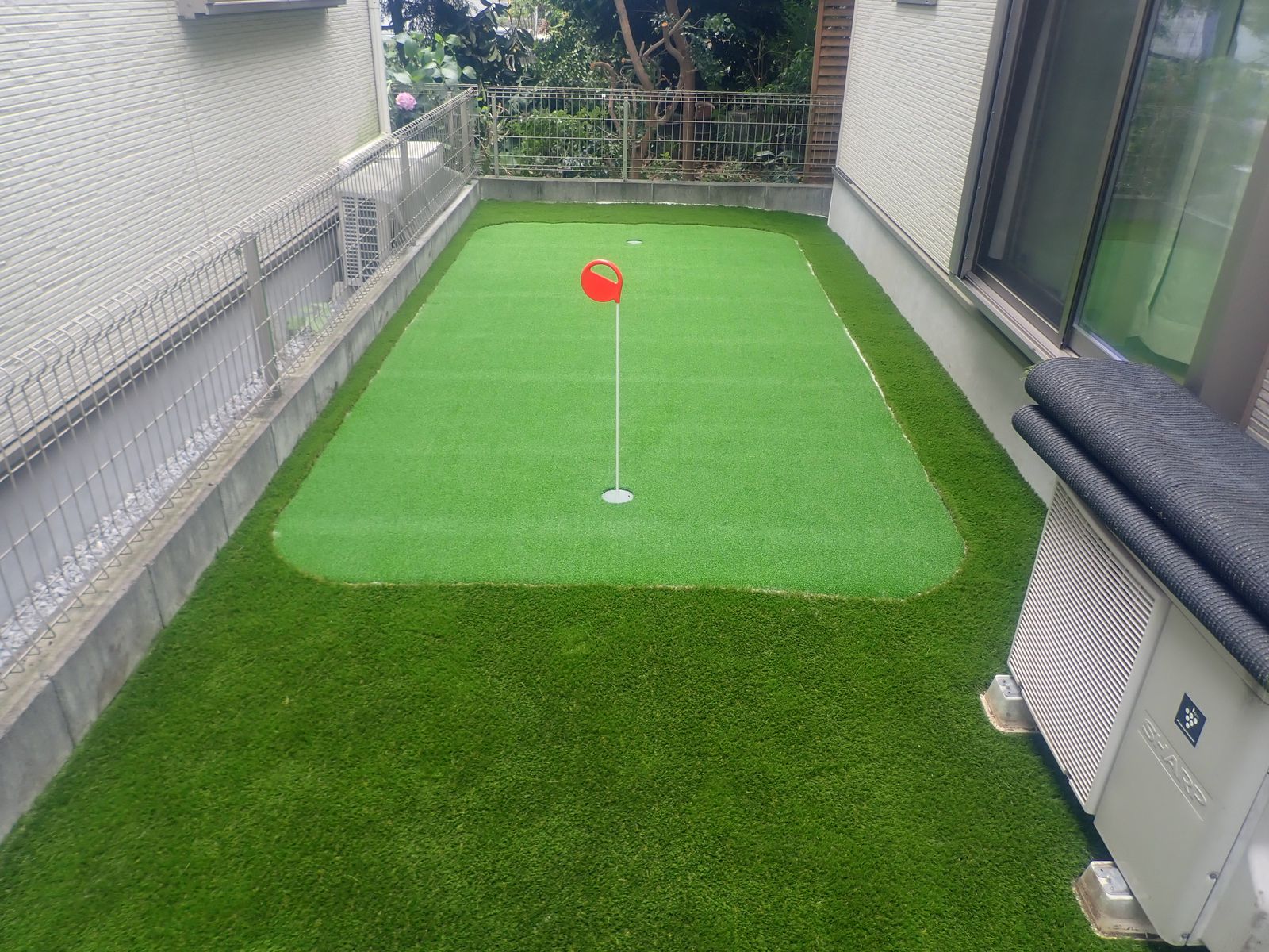 住宅の裏庭に施工したゴルフパター練習用人工芝、カップ2箇所設置
