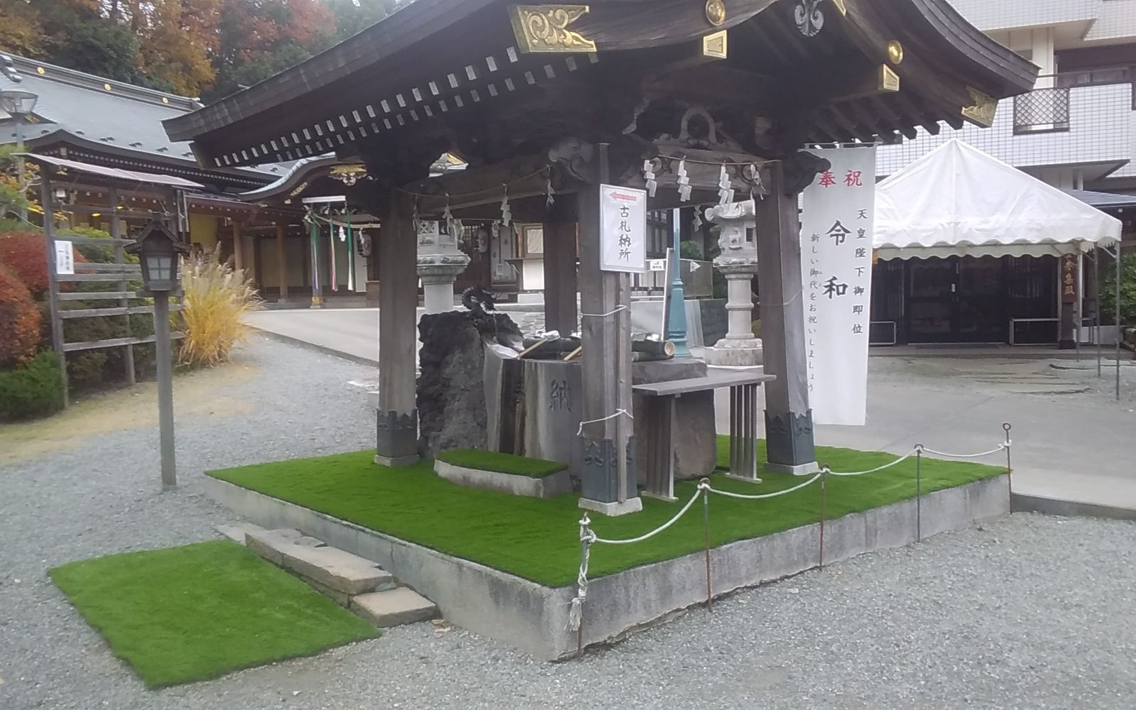 神社境内の手水舎まわりに施工した人工芝と玉砂利の境目