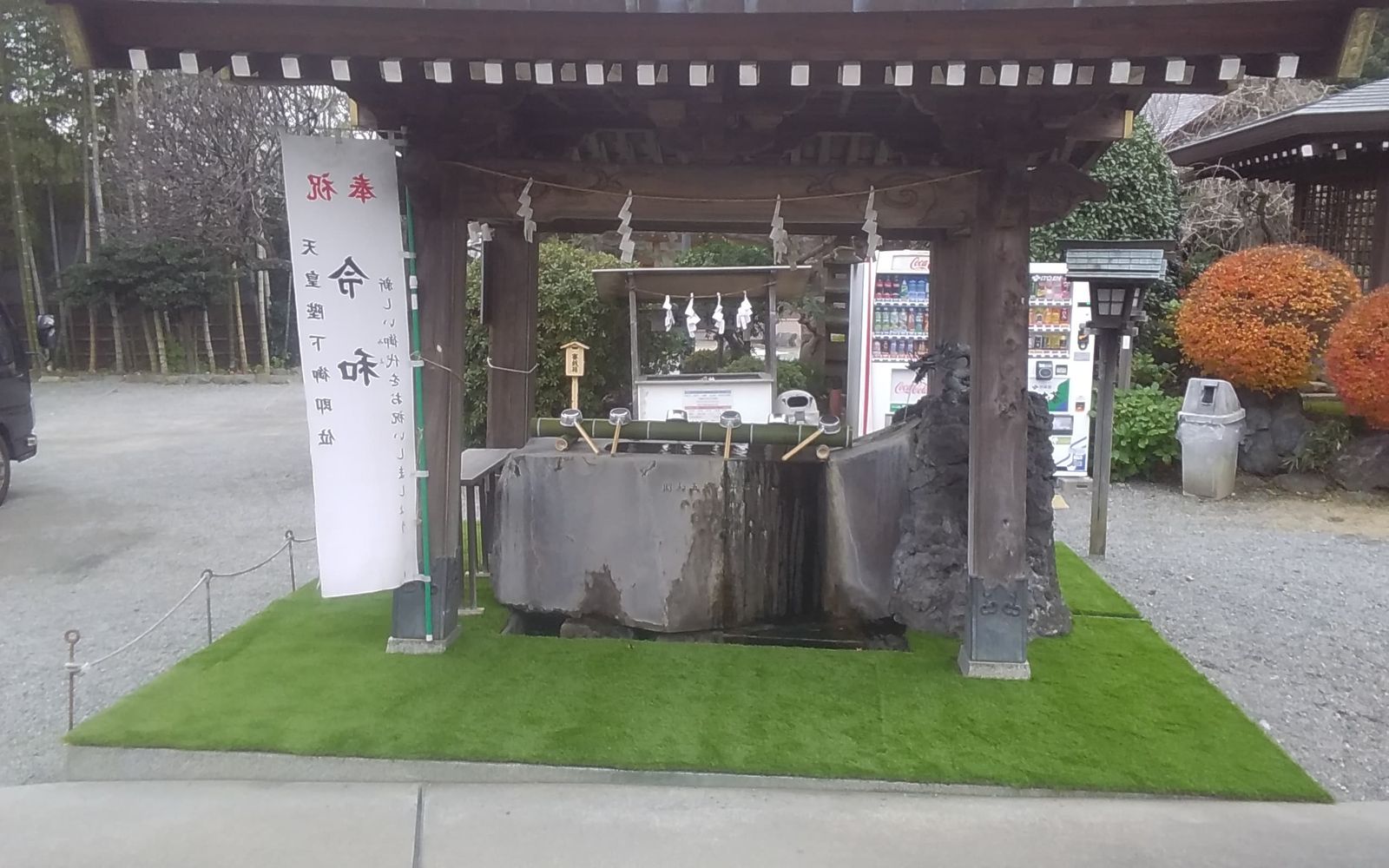 神社境内での人工芝施工中の様子、石組みまわりを丁寧に仕上げる