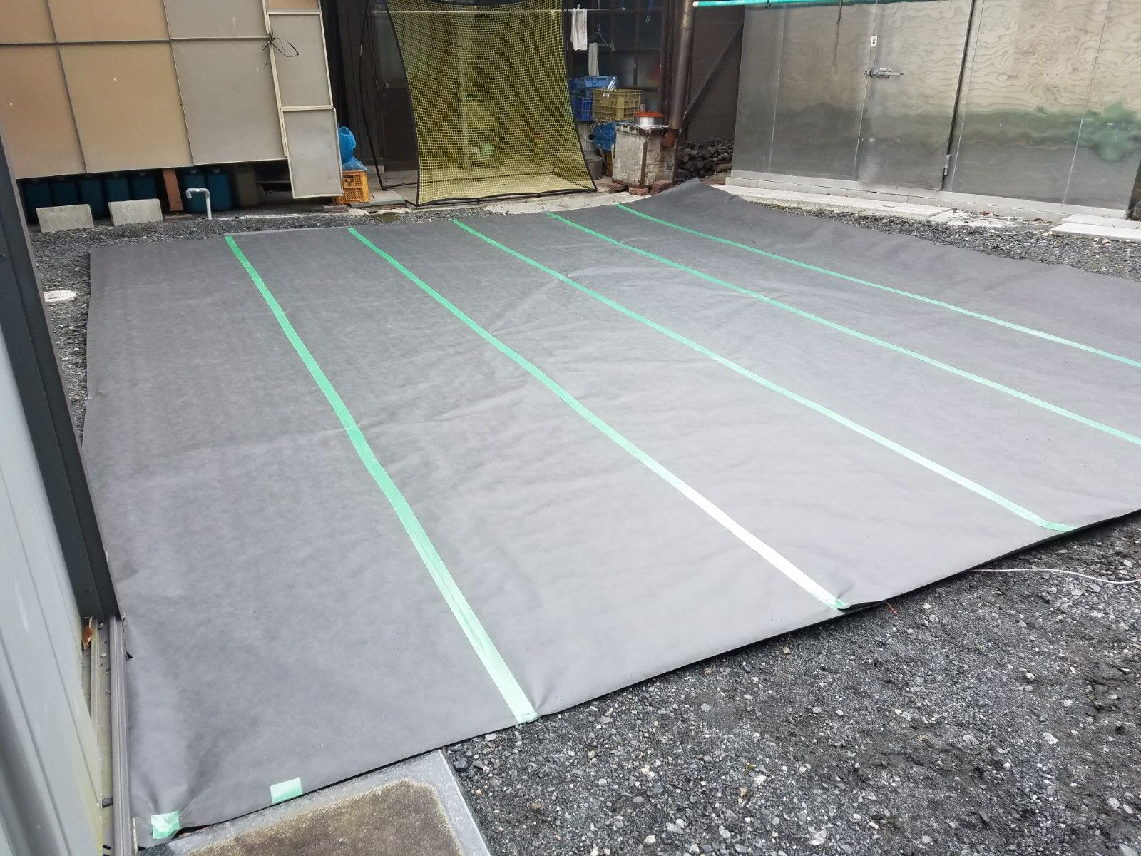 人工芝施工の防草シート・下地マット敷設作業