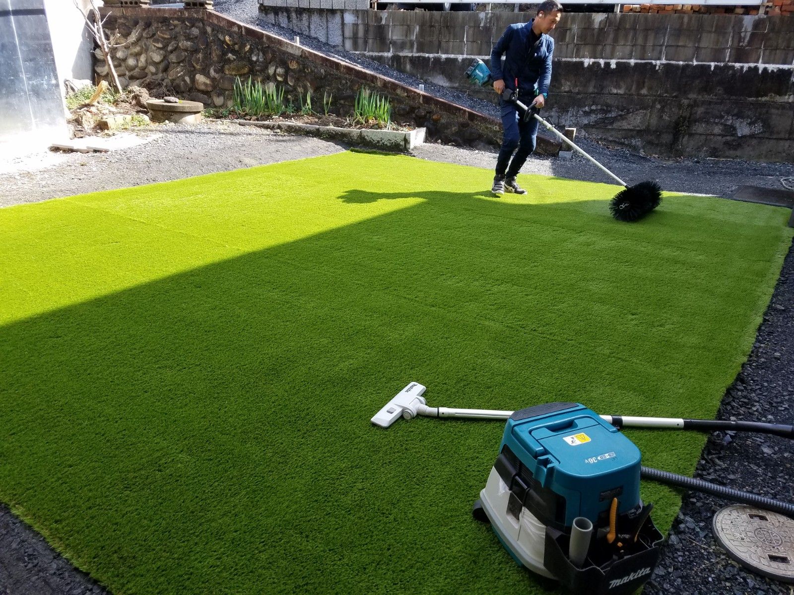 人工芝施工後の仕上げ作業をするスタッフ