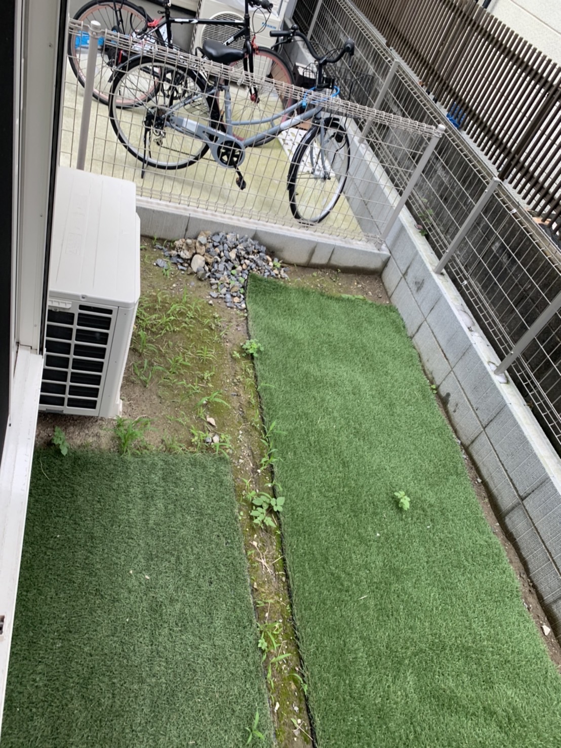 施工前:置き敷きの人工芝マットの隙間から雑草が伸びたお庭