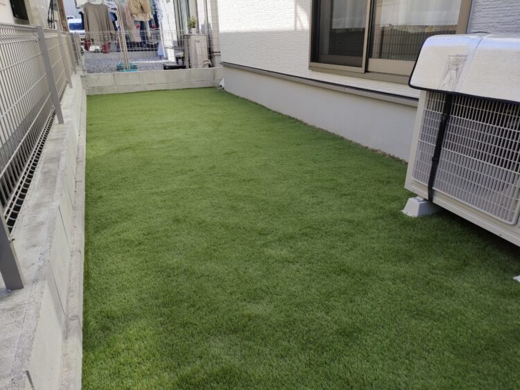物干しスタンドの立つ住宅脇の裏庭を素足で歩ける緑に｜那覇市の人工芝施工事例