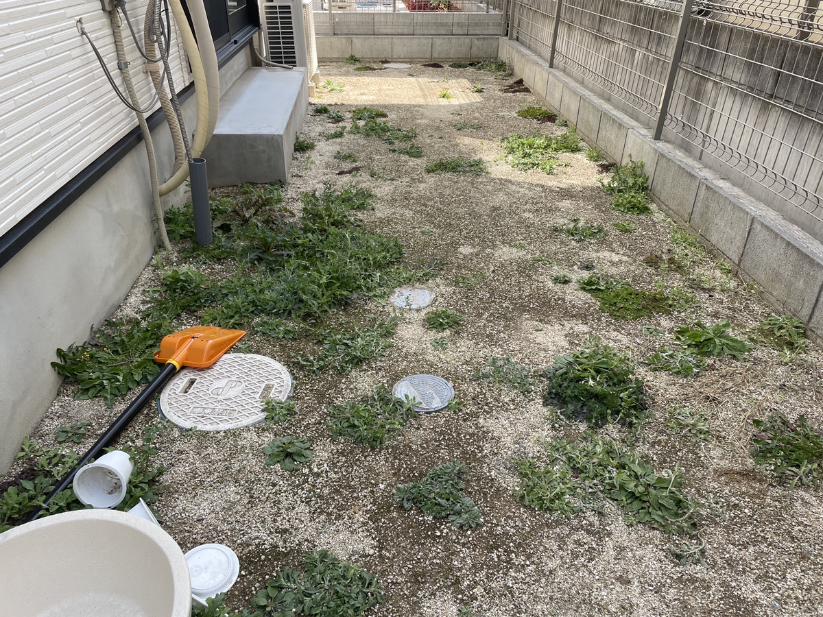 施工前:雑草が伸びた建物脇の砂利敷きスペース