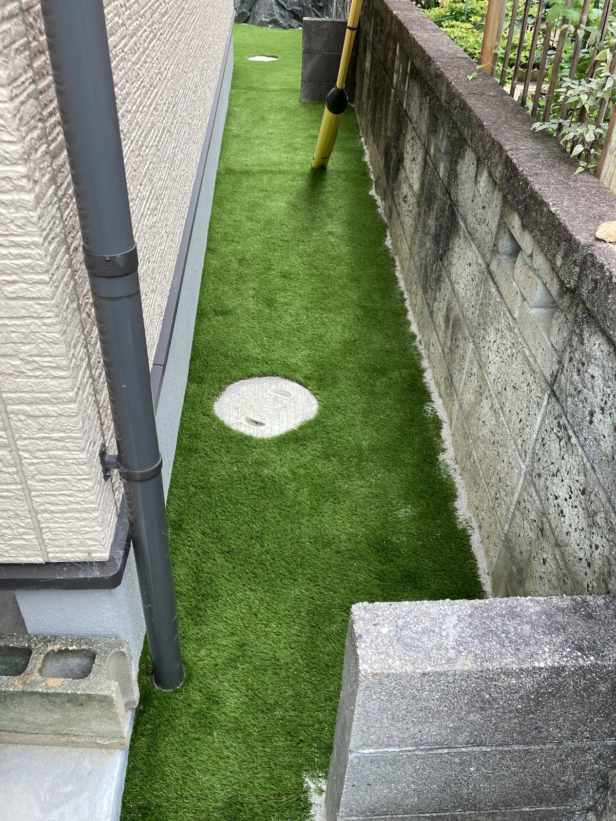 施工後：建物脇の細い通路が新しい人工芝に