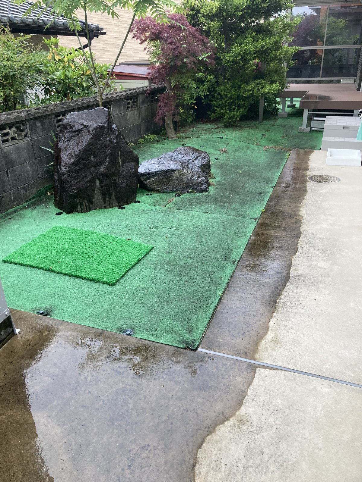 施工前：庭石まわりに敷かれた色あせた既存の人工芝