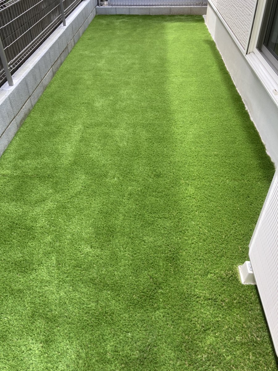 施工後：同じ建物脇が一面の人工芝に