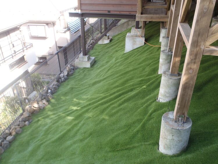 ウッドデッキ下の法面を凹凸のないなめらかな緑の斜面に｜人工芝施工事例