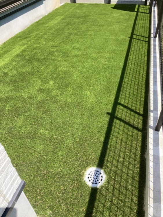 水はけを保ちたい建物脇を排水枡まで隙間なく敷いた緑に｜人工芝施工事例