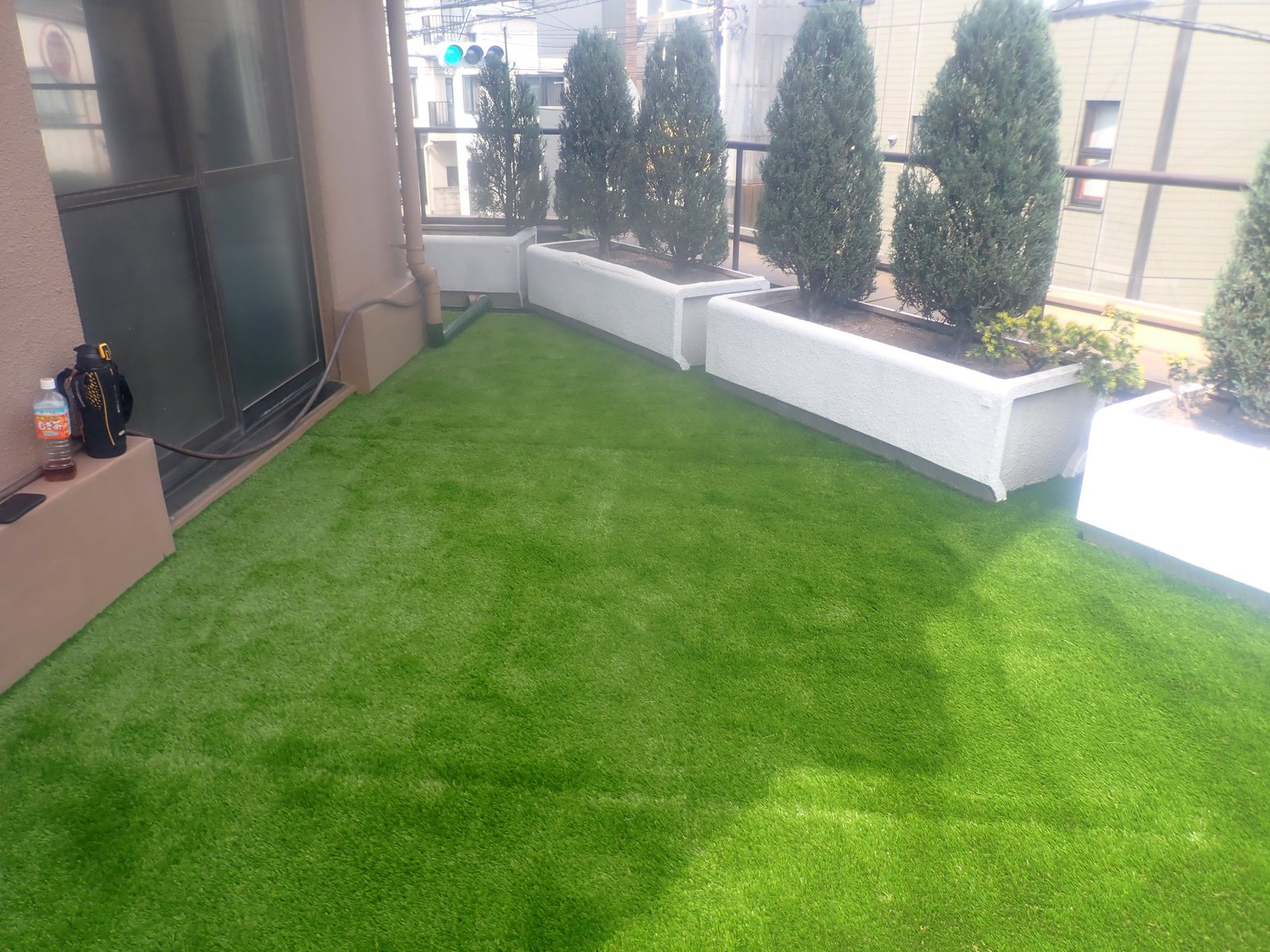 施工後:プランターと植栽が並ぶルーフバルコニーが一面の人工芝に