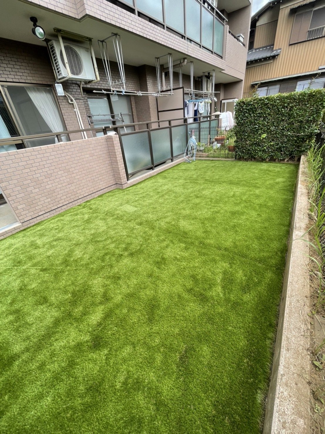 施工後:物干しのあるベランダ側から見た専用庭の人工芝