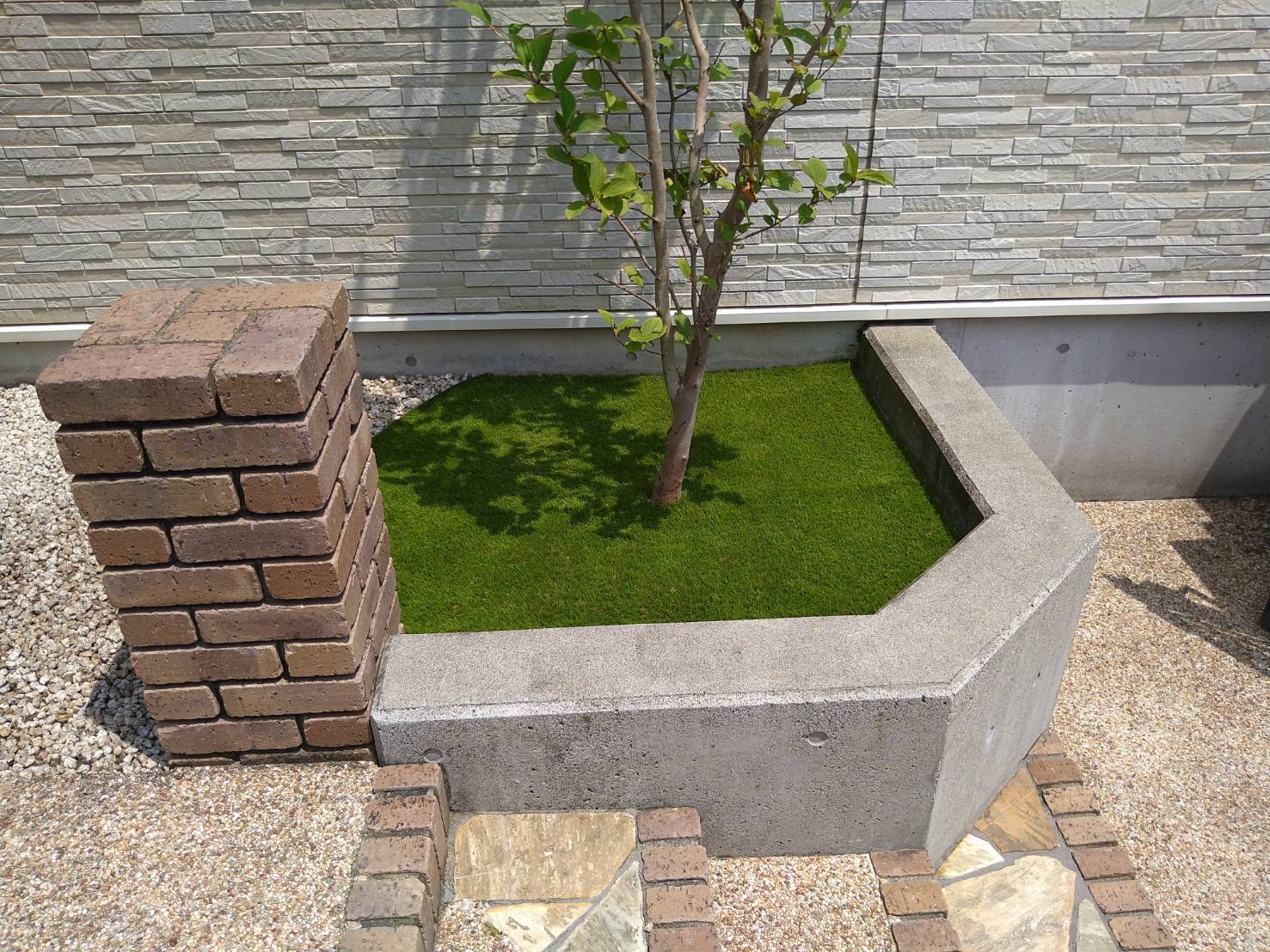施工後:庭木を残した花壇の中が人工芝に
