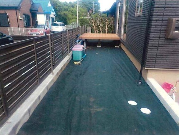 施工前：防草シートを張った状態のバルコニー状スペース