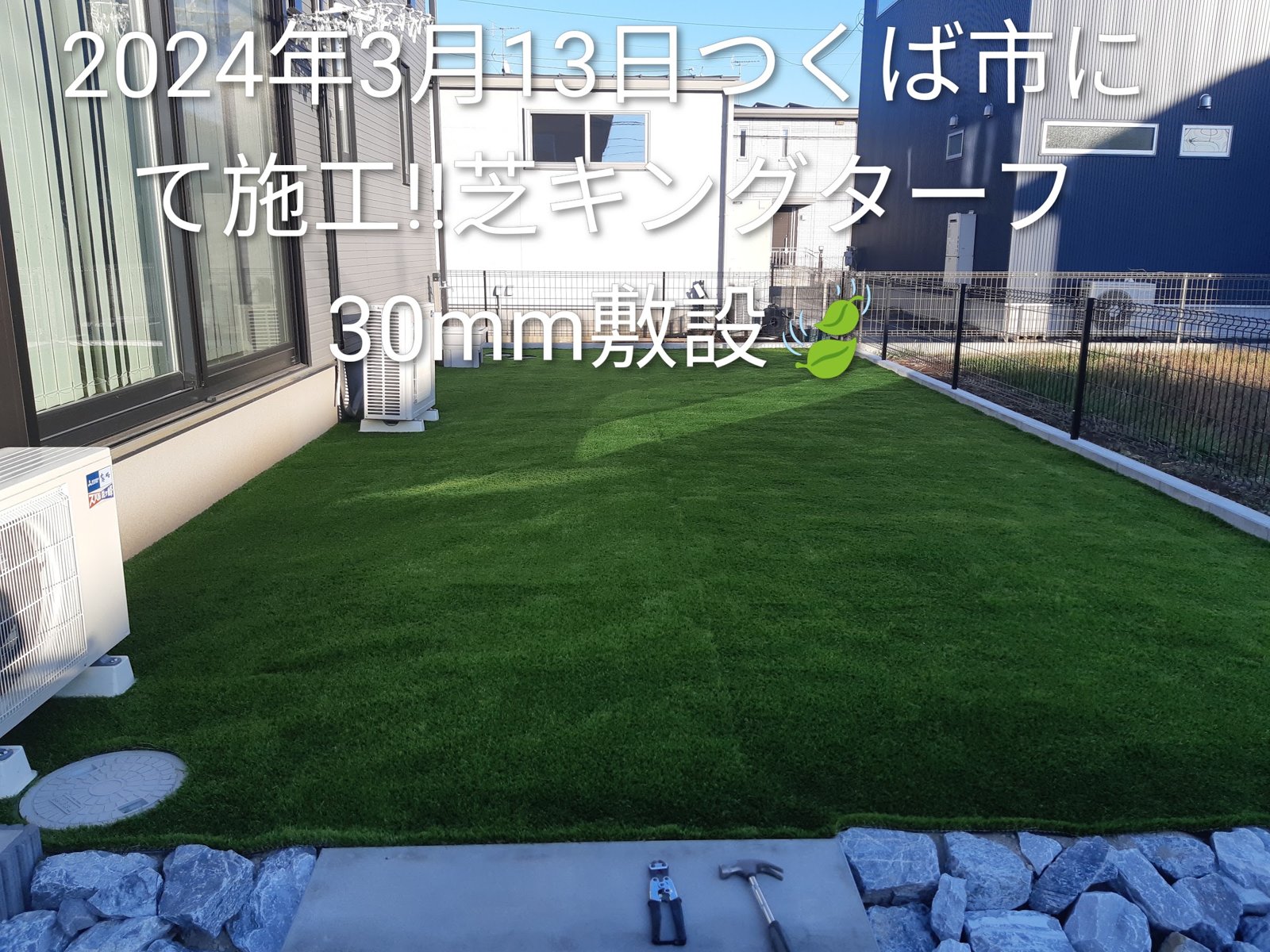 施工後:石積みの縁取りに囲まれたお庭が人工芝に