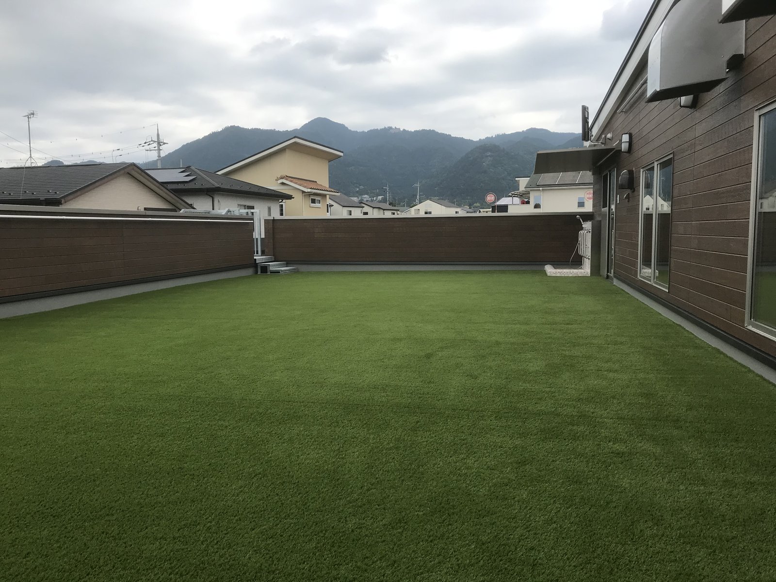 施工後:山並みを望む屋上バルコニーの人工芝全景