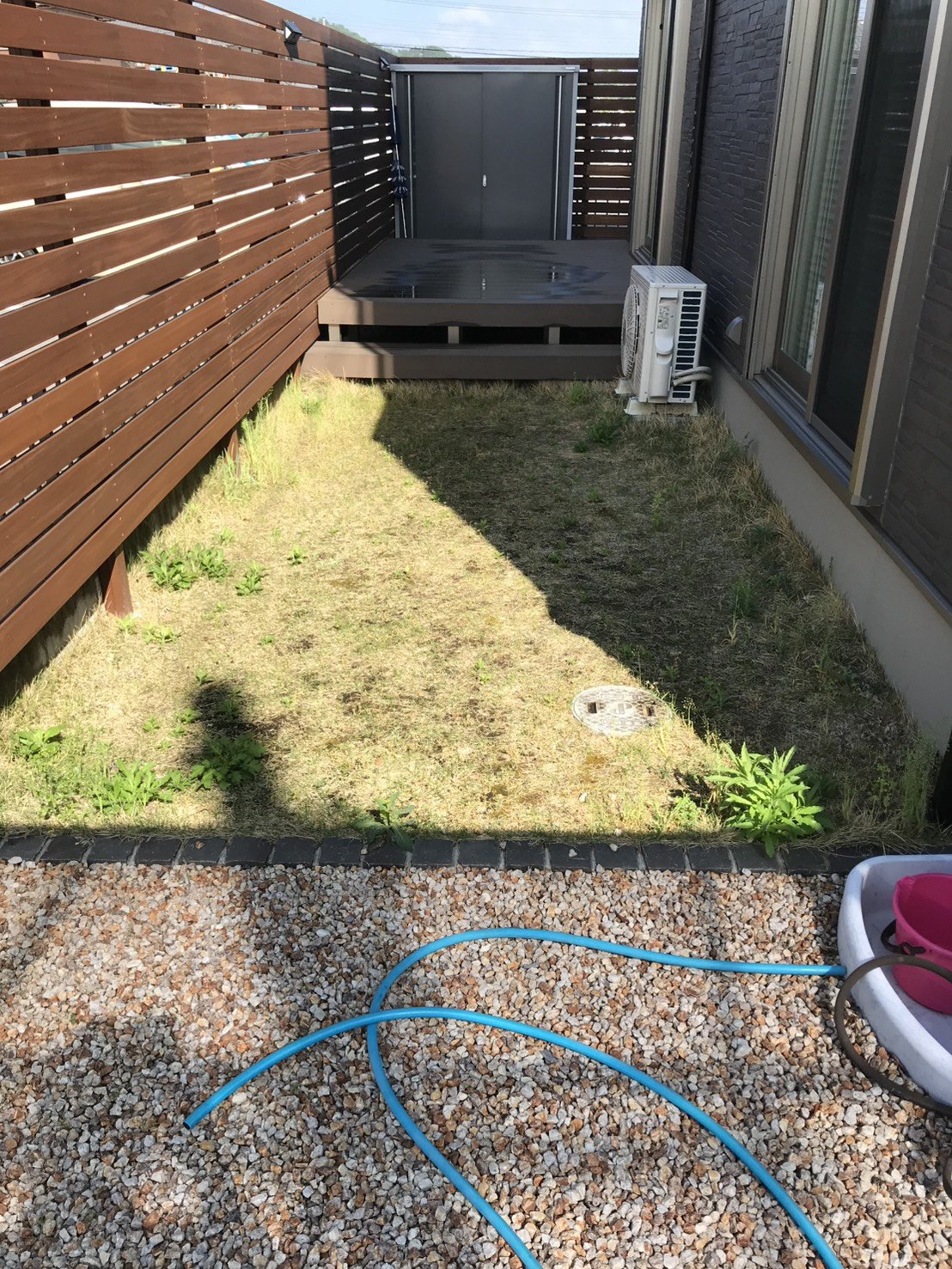施工前:枯れて雑草が混じった天然芝の建物脇