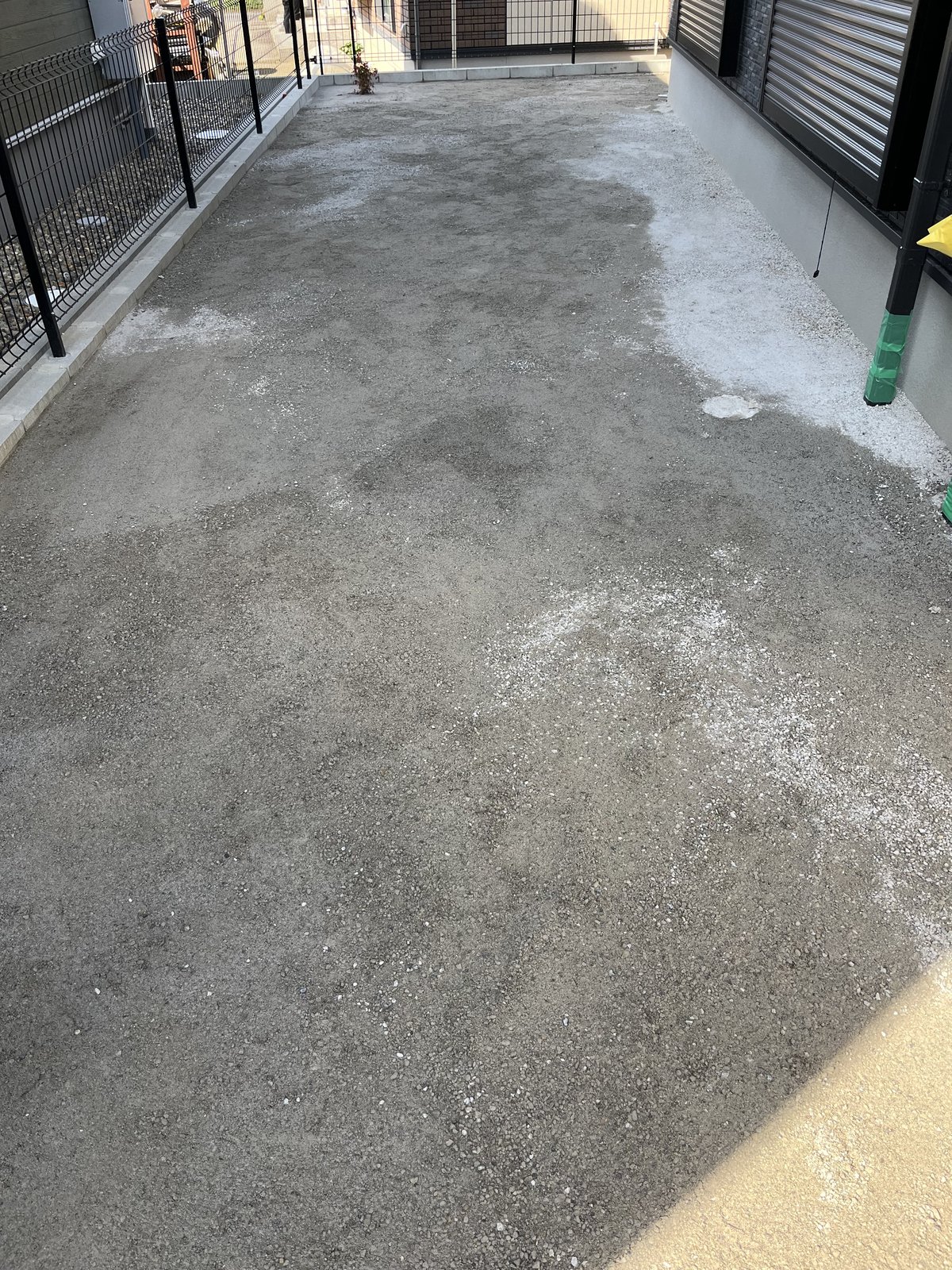 施工前：砕石がむき出しの建物まわりの通路