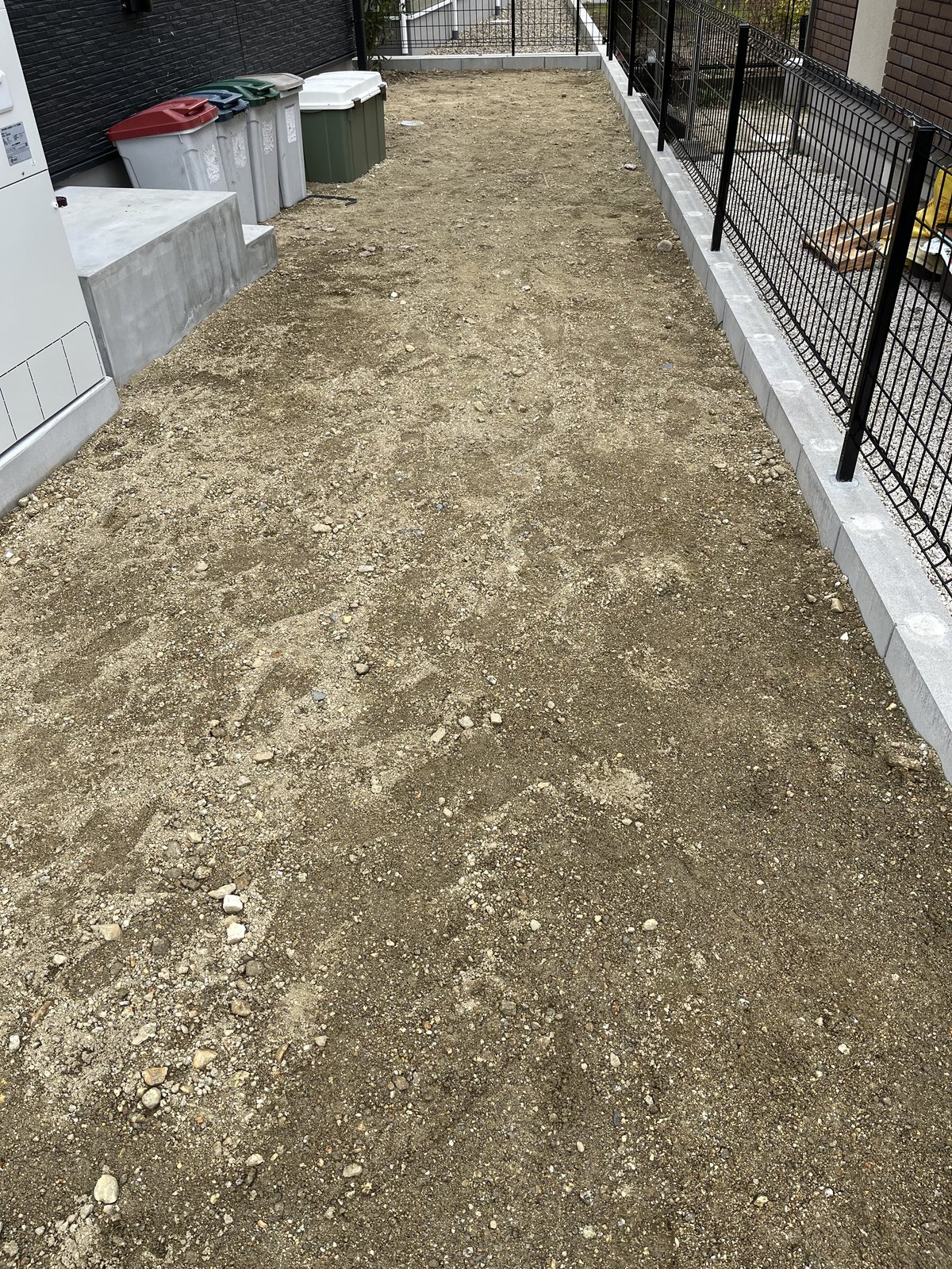 施工前：土と小石が見える裏庭の通路
