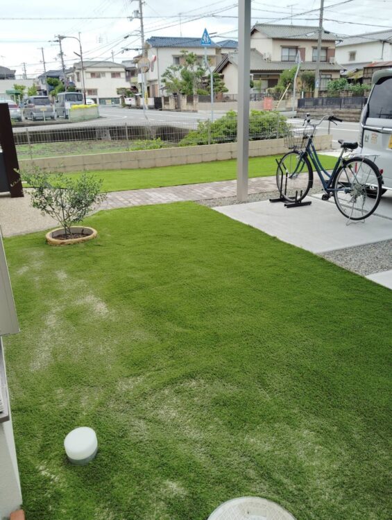 自転車置き場まで続く玄関前の前庭を来客に映える緑に｜加古郡の人工芝施工事例