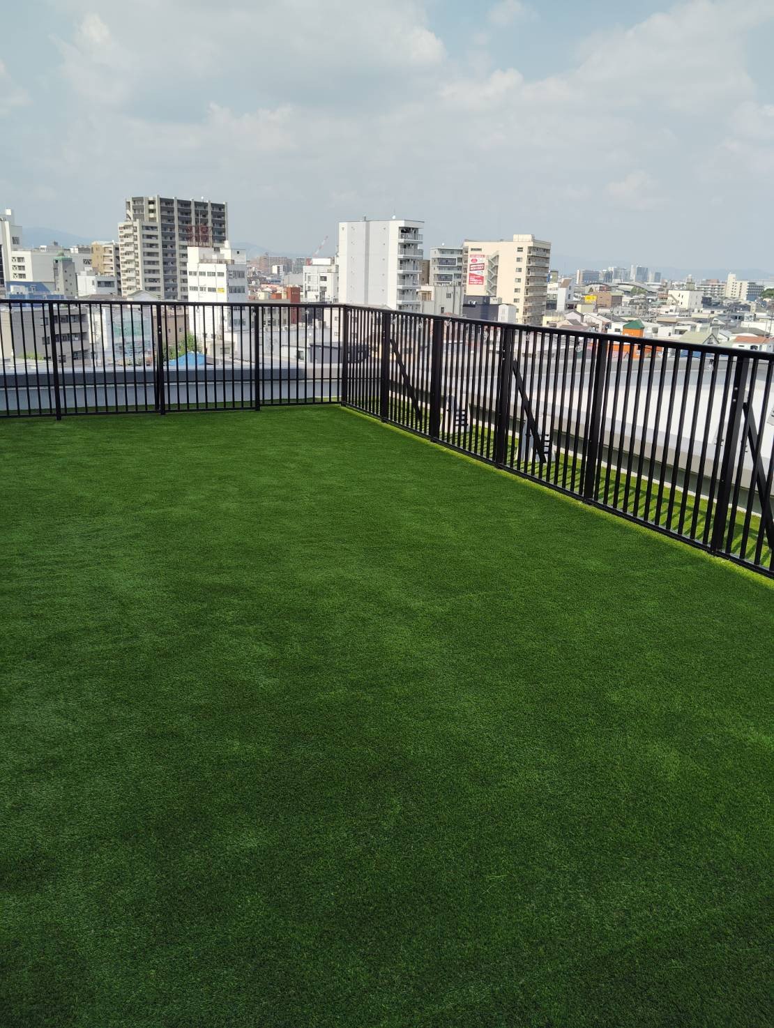 施工後：ルーフバルコニーに敷かれた人工芝と市街地の眺望