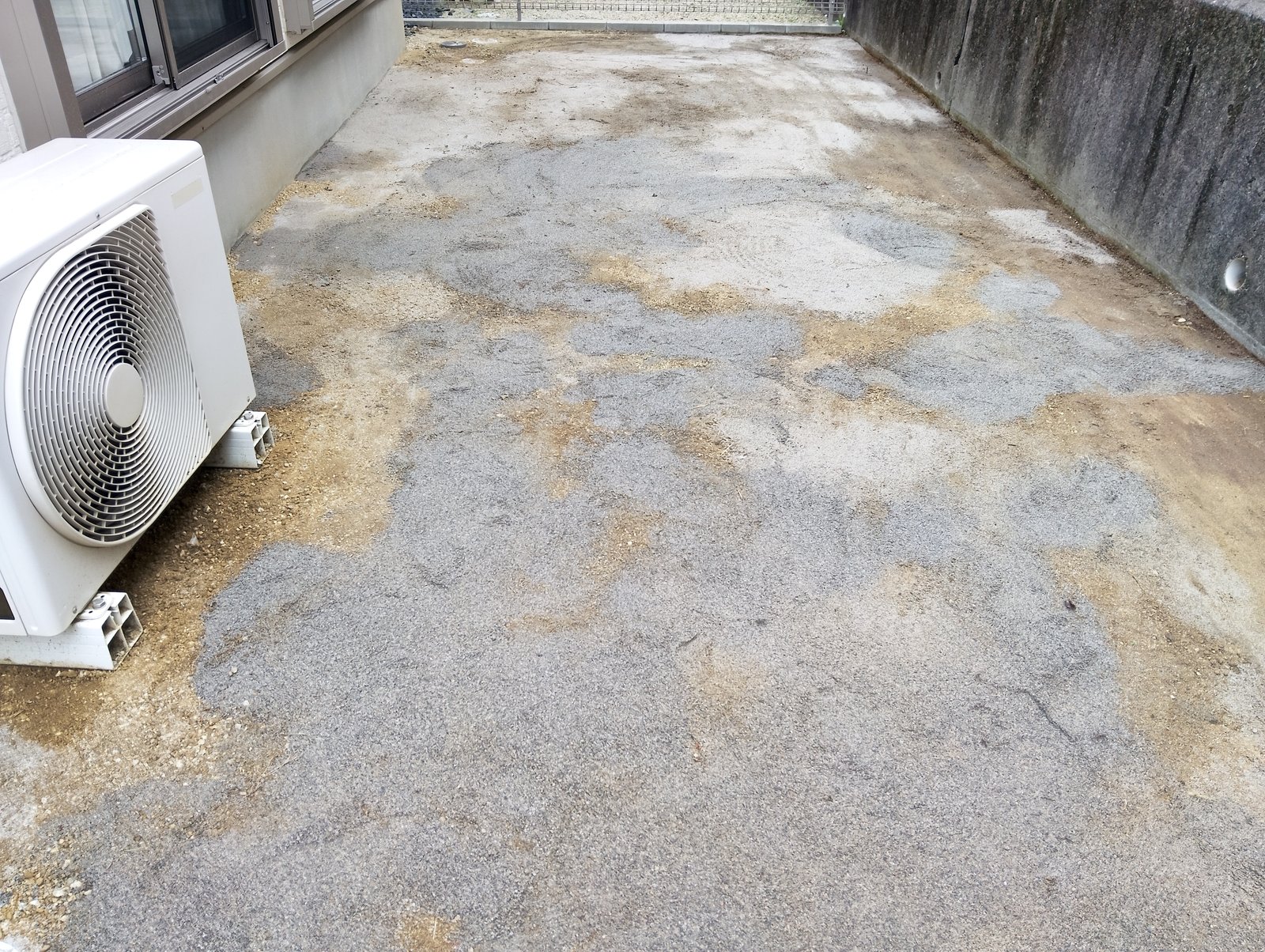 施工前:エアコン室外機まわりの砂利と山砂の地面